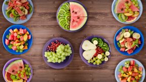 צלחות עם פירות על שולחן עץ מן התקשורת פירות העוזרים לנדודי שינה או ג'ט לג