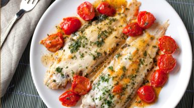 פרוסות דג עם עגבניות שרי מוגשות על צלחת לבנה מתכון לפרוסות דג מושט ועגבניות שרי