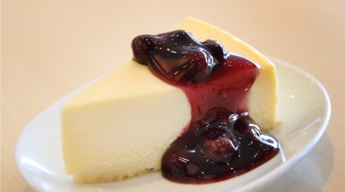 פרוסת עוגת גבינה עם רוטב אוכמניות מתכון לקינוח דיאטתי בריא וטעים