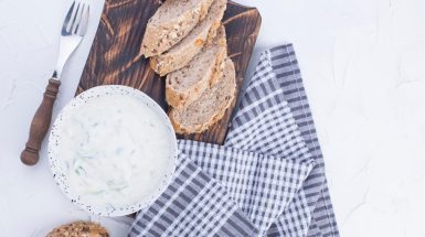 ממרח גבינה עם מללפון מגורד מוגש על קרש עץ עם פרוסות לחם