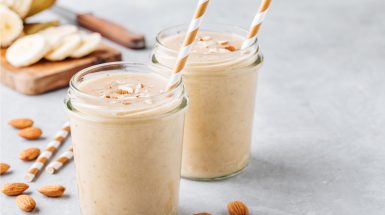 שייק פירות בתוך צנצנת עם קשית בפנים עם שבבי שקדים מעל