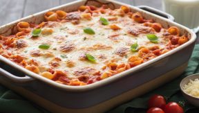 מאפה פסטה מוקרם בתנור עם גבינה מותכת, רוטב עגבניות ועלי בזיליקום טריים בתבנית הגשה