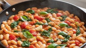 תבשיל שעועית לבנה ברוטב עגבניות עם עלי בזיליקום טריים, שום ועגבניות שרי במחבת